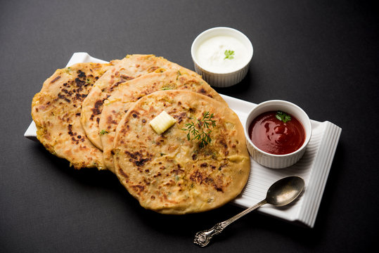 Aloo Paratha / Indian Potato stuffed Flatbread. Served with fresh curd and tomato ketchup. selective focus
