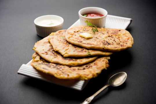 Aloo Paratha / Indian Potato stuffed Flatbread. Served with fresh curd and tomato ketchup. selective focus