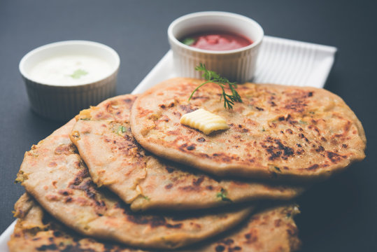 Aloo Paratha / Indian Potato stuffed Flatbread. Served with fresh curd and tomato ketchup. selective focus