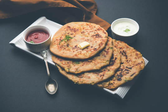 Aloo Paratha / Indian Potato stuffed Flatbread. Served with fresh curd and tomato ketchup. selective focus
