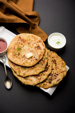 Aloo Paratha / Indian Potato stuffed Flatbread. Served with fresh curd and tomato ketchup. selective focus