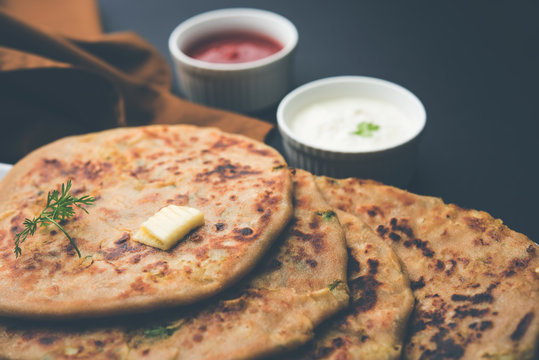 Aloo Paratha / Indian Potato stuffed Flatbread. Served with fresh curd and tomato ketchup. selective focus