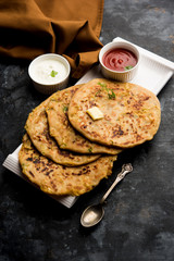Aloo Paratha / Indian Potato stuffed Flatbread. Served with fresh curd and tomato ketchup. selective focus