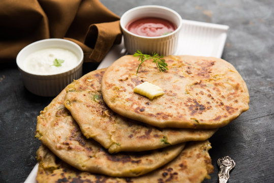 Aloo Paratha / Indian Potato stuffed Flatbread. Served with fresh curd and tomato ketchup. selective focus