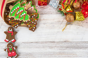 Beautiful Christmas composition and decoration with baked Christmas gingerbread cookies in paper bag on light wooden background, flat lay, top view, copy space (text space)