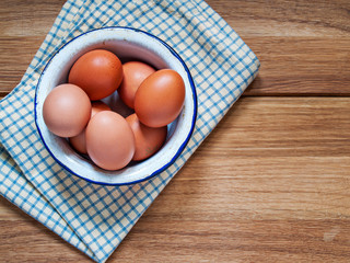 Many chicken eggs lie in an enamel bowl