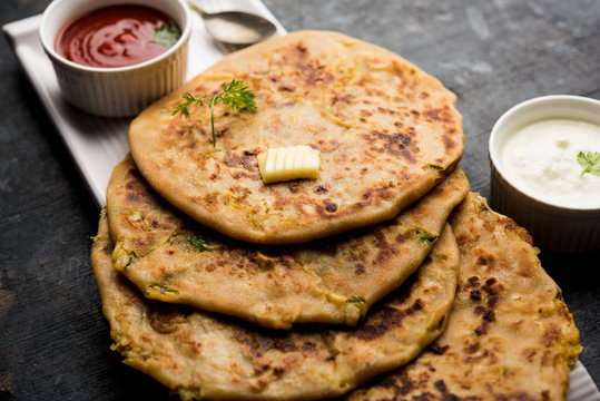 Aloo Paratha / Indian Potato stuffed Flatbread. Served with fresh curd and tomato ketchup. selective focus