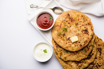 Aloo Paratha / Indian Potato stuffed Flatbread. Served with fresh curd and tomato ketchup. selective focus