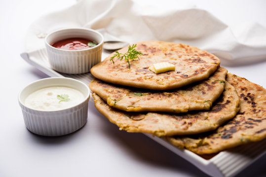 Aloo Paratha / Indian Potato stuffed Flatbread. Served with fresh curd and tomato ketchup. selective focus