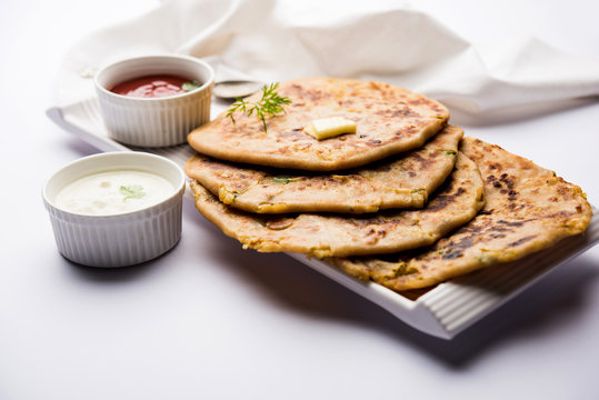 Aloo Paratha / Indian Potato stuffed Flatbread. Served with fresh curd and tomato ketchup. selective focus