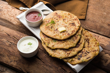 Aloo Paratha / Indian Potato stuffed Flatbread. Served with fresh curd and tomato ketchup. selective focus