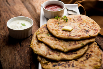 Aloo Paratha / Indian Potato stuffed Flatbread. Served with fresh curd and tomato ketchup. selective focus
