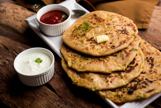 Aloo Paratha / Indian Potato stuffed Flatbread. Served with fresh curd and tomato ketchup. selective focus