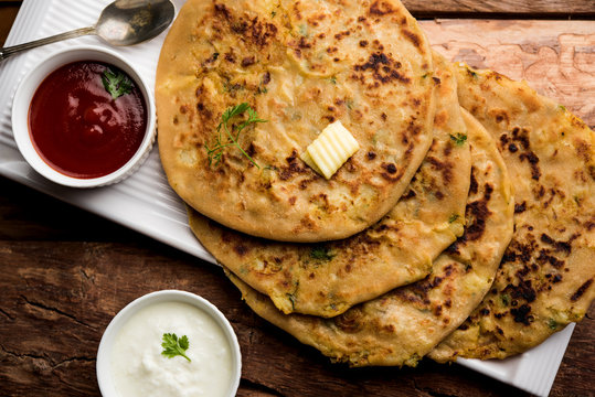 Aloo Paratha / Indian Potato stuffed Flatbread. Served with fresh curd and tomato ketchup. selective focus