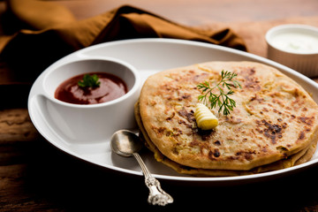 Aloo Paratha / Indian Potato stuffed Flatbread. Served with fresh curd and tomato ketchup. selective focus