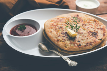 Aloo Paratha / Indian Potato stuffed Flatbread. Served with fresh curd and tomato ketchup. selective focus