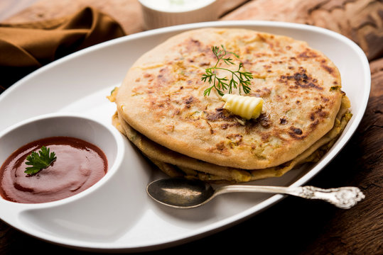 Aloo Paratha / Indian Potato stuffed Flatbread. Served with fresh curd and tomato ketchup. selective focus