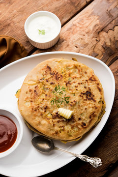 Aloo Paratha / Indian Potato stuffed Flatbread. Served with fresh curd and tomato ketchup. selective focus