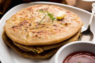 Aloo Paratha / Indian Potato stuffed Flatbread. Served with fresh curd and tomato ketchup. selective focus