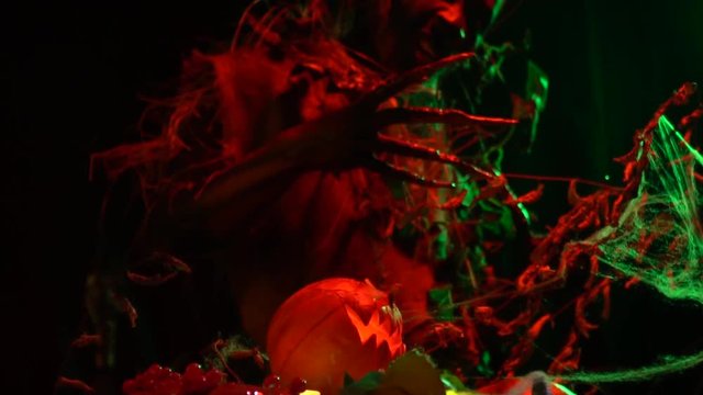 Frightening halloween monster screams among pumpkins, slow motion