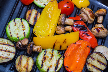 Cooking vegetables and mushrooms on grill pan 