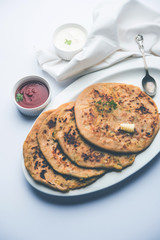Aloo Paratha / Indian Potato stuffed Flatbread. Served with fresh curd and tomato ketchup. selective focus