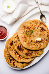 Aloo Paratha / Indian Potato stuffed Flatbread. Served with fresh curd and tomato ketchup. selective focus