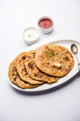 Aloo Paratha / Indian Potato stuffed Flatbread. Served with fresh curd and tomato ketchup. selective focus