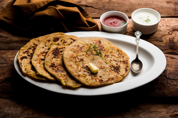 Aloo Paratha / Indian Potato stuffed Flatbread. Served with fresh curd and tomato ketchup. selective focus