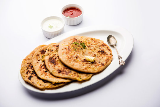 Aloo Paratha / Indian Potato stuffed Flatbread. Served with fresh curd and tomato ketchup. selective focus