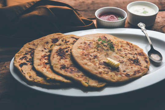 Aloo Paratha / Indian Potato stuffed Flatbread. Served with fresh curd and tomato ketchup. selective focus