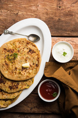 Aloo Paratha / Indian Potato stuffed Flatbread. Served with fresh curd and tomato ketchup. selective focus