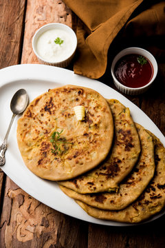 Aloo Paratha / Indian Potato stuffed Flatbread. Served with fresh curd and tomato ketchup. selective focus