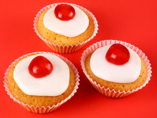 THREE CHERRY CUPCAKES ON RED