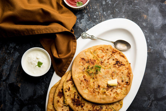 Aloo Paratha / Indian Potato stuffed Flatbread. Served with fresh curd and tomato ketchup. selective focus