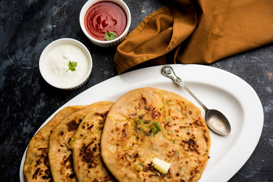 Aloo Paratha / Indian Potato stuffed Flatbread. Served with fresh curd and tomato ketchup. selective focus