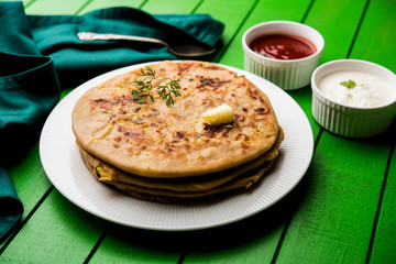 Aloo Paratha / Indian Potato stuffed Flatbread. Served with fresh curd and tomato ketchup. selective focus