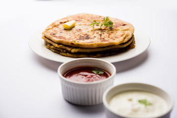 Aloo Paratha / Indian Potato stuffed Flatbread. Served with fresh curd and tomato ketchup. selective focus