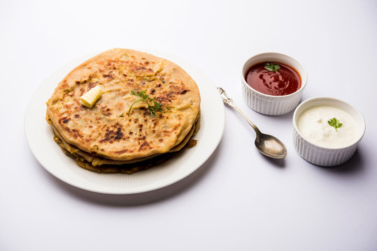 Aloo Paratha / Indian Potato stuffed Flatbread. Served with fresh curd and tomato ketchup. selective focus