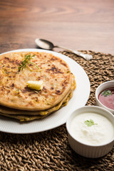 Aloo Paratha / Indian Potato stuffed Flatbread. Served with fresh curd and tomato ketchup. selective focus