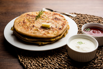Aloo Paratha / Indian Potato stuffed Flatbread. Served with fresh curd and tomato ketchup. selective focus