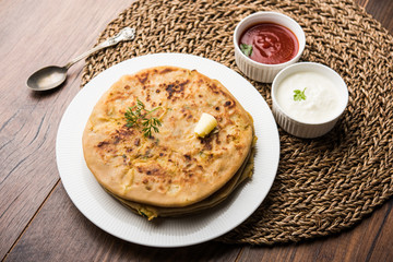 Aloo Paratha / Indian Potato stuffed Flatbread. Served with fresh curd and tomato ketchup. selective focus