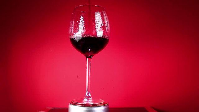 Red wine in glass on colorful background