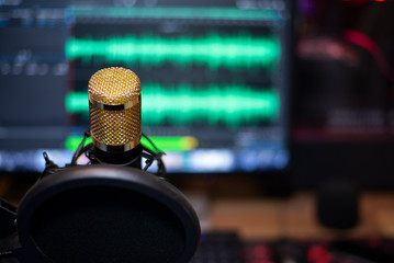 Golden microphone at audio recording, On computer, There is a background audio signal, Close-up.