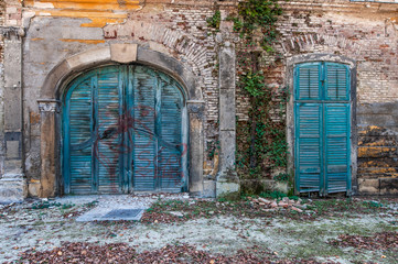 ancient turquoise colored wooden entrance doors sprayed with graffiti in Hungary