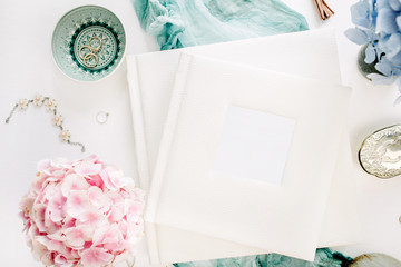 Family wedding photo album, pastel colorful hydrangea flower bouquet, turquoise blanket, decoration on white background. Flat lay, top view festive mockup.