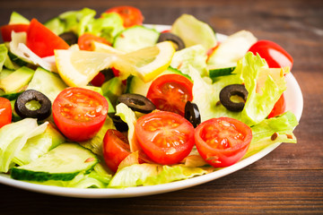 Salad of tomatoes, cucumbers, green salad, olives and seeds
