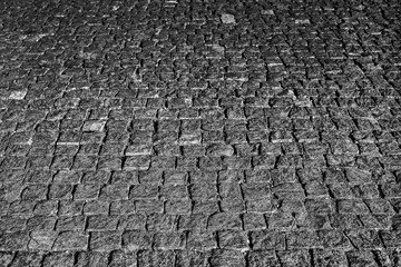 Fototapeta premium Stone road close up. Old pavement of granite. Gray square cobblestone sidewalk. Mock up or vintage grunge texture.