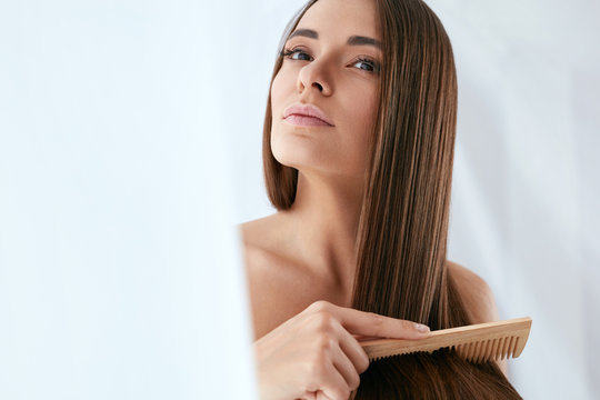Beauty Hair Care. Beautiful Woman Combing Long Natural Hair