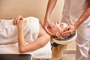 man physiotherapist hands, massage woman face head.